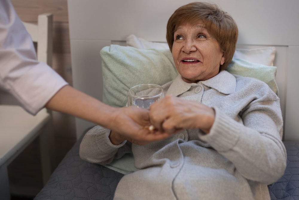 Per prendersi cura di un anziano, in una casa di riposo, serve non soltanto assolvere ai suoi bisogni pratici, ma anche farlo vivere in un ambiente felice e sereno. Nella foto, una donna accudita da un'infermiera in una casa di riposo.