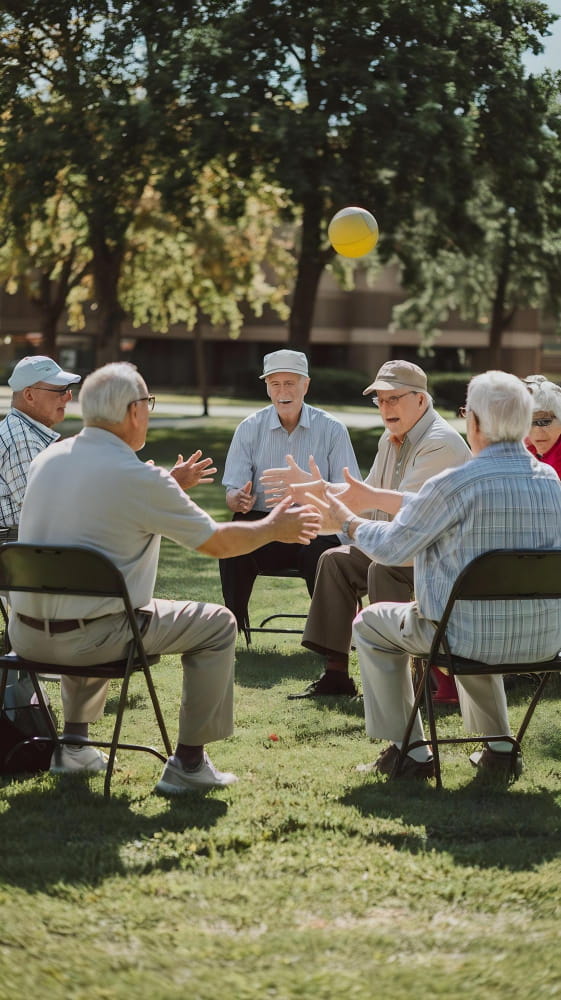 Un ambiente sociale in una casa di riposo deve offrire spazi di condivisione e di libertà come giardini e sali comuni. Nella foto, un gruppo di anziani che conversano a un tavolo in giardino.